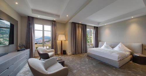 ロクブリュヌ・カップ・マルタンにあるLuxurious Villa Overlooking Monacoのベッド1台と椅子2脚が備わるホテルルームです。