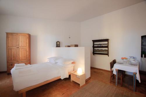 ein Schlafzimmer mit einem weißen Bett und einem Tisch in der Unterkunft Traditional Studio in Alfama in Lissabon