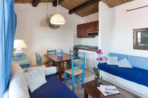 uma sala de estar com um sofá azul e uma mesa em Residence I Cormorani Alti em Baja Sardinia