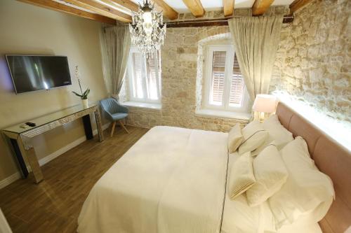 Rooms Skoblar في زادار: غرفة نوم بسرير ابيض وتلفزيون