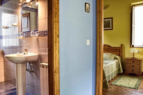 y baño con lavabo y espejo. en Apartamentos Rio Tabardin, en Llano-Con