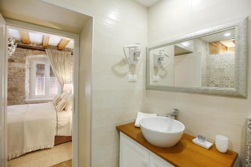łazienka z umywalką, lustrem i łóżkiem w obiekcie Rooms Skoblar w mieście Zadar