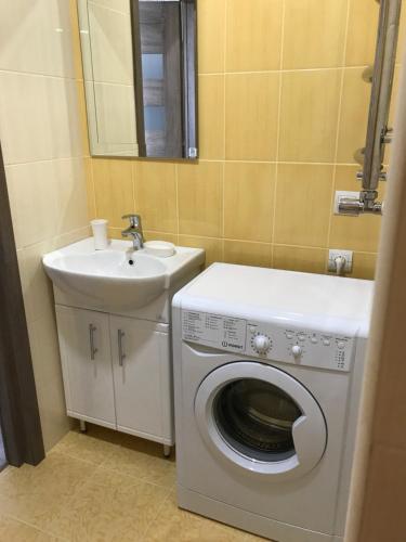 a bathroom with a washing machine and a sink at Apartment Riviera in Fontanka