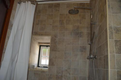 ein Bad mit Dusche und Duschvorhang in der Unterkunft Casinha da Avó Maria in Alcobaça