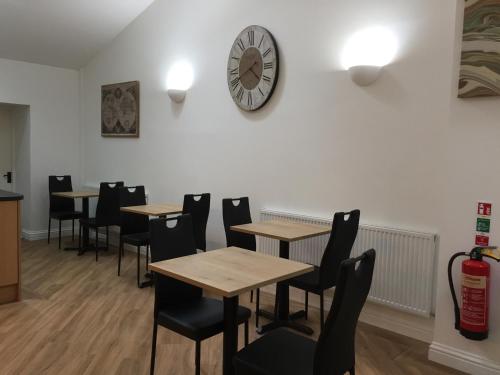 a restaurant with tables and chairs and a clock on the wall at Fir Tree Barn in Pollington