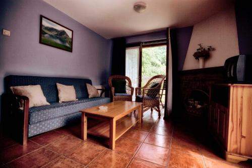 sala de estar con sofá azul y mesa en Apartamentos Rio Tabardin, en Llano-Con