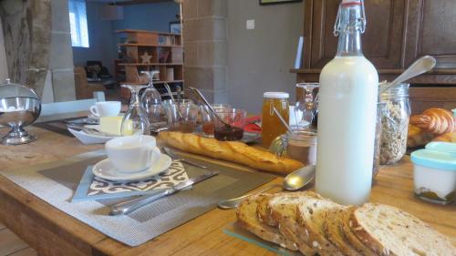 een tafel met brood en een fles melk bij A la belle histoire in Châteauneuf-sur-Isère