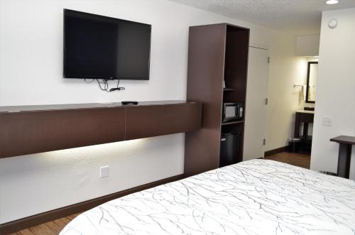 a bedroom with a bed and a flat screen tv at Athena Inn Chattanooga in Chattanooga