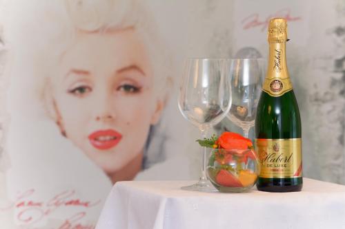 a bottle of champagne and two wine glasses on a table at Apartments Marilyn in Tatranská Lomnica