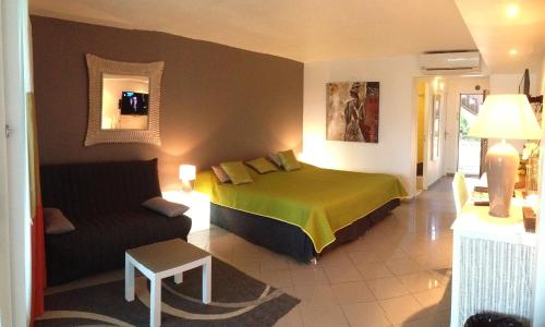 a hotel room with a bed and a couch at Studio De Charme in Le Gosier