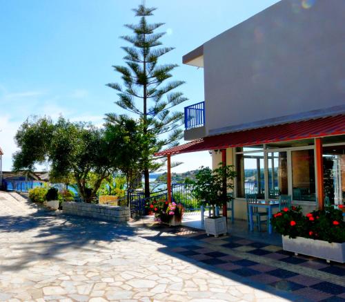 a pine tree in front of a building at Hotel Golden Sun in Finikounta