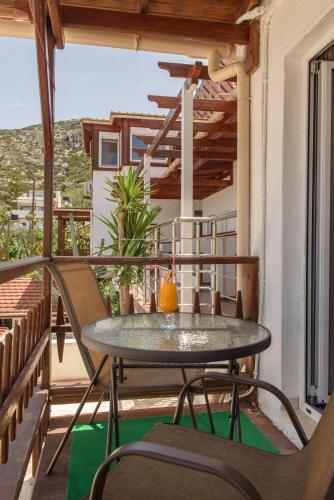 a patio with a table and chairs on a balcony at Nikos Hotel in Matala