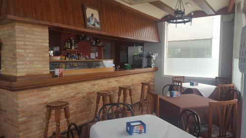 a restaurant with a bar with tables and chairs at Hotel Banyeres in Bañeres de Mariola