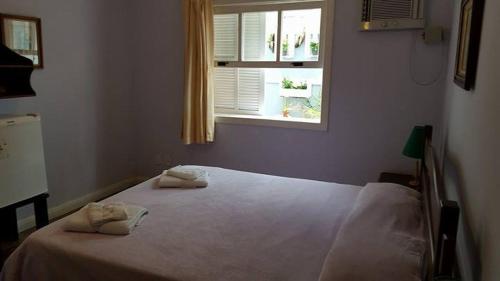 a bedroom with a bed with two towels on it at Pousada D'amoras in Conservatória