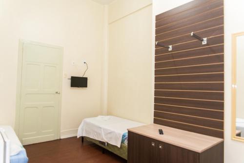 a room with a bed and a wooden wall at Hotel Palácio - Próx ao Hospital Santa Casa in Porto Alegre
