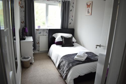 a small bedroom with a bed and a window at 103 Bewick Serviced Accommodation in Newton Aycliffe