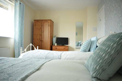 a bedroom with two beds and a television in it at 103 Bewick Serviced Accommodation in Newton Aycliffe