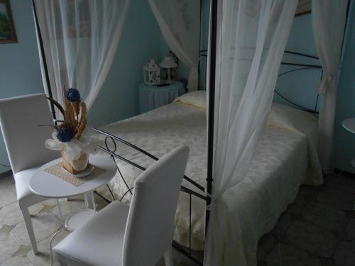Schlafzimmer mit einem Bett, einem Tisch und Stühlen in der Unterkunft Garden Villa Sea View in Riomaggiore
