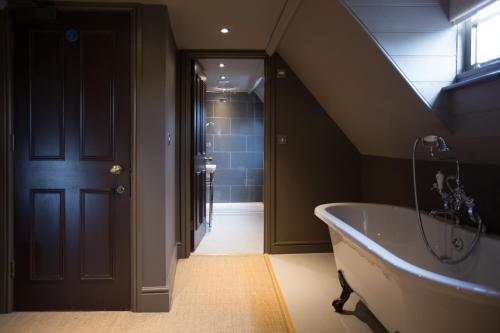 The Minster Arms في ويمبورن مينستر: حمام مع حوض وحوض استحمام في الغرفة