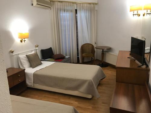 a hotel room with a bed and a television at Hotel Levadia in Levádeia