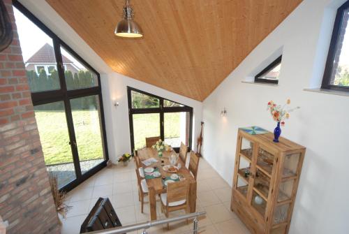 a dining room with a table and some windows at Haus über den Dächern von Heiligenhafen in Heiligenhafen