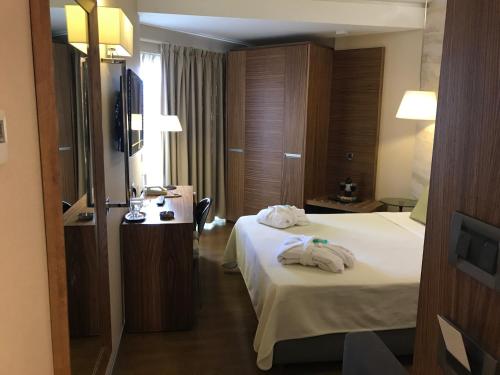 a hotel room with a bed with towels on it at Hotel Levadia in Levádeia