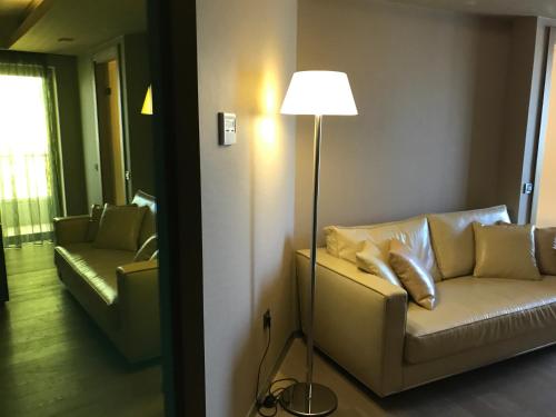 a living room with a couch and a floor lamp at Hotel Levadia in Levádeia