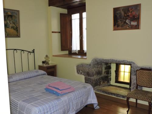1 dormitorio con 1 cama y chimenea en Balkonpe Landa Etxea, en Udave