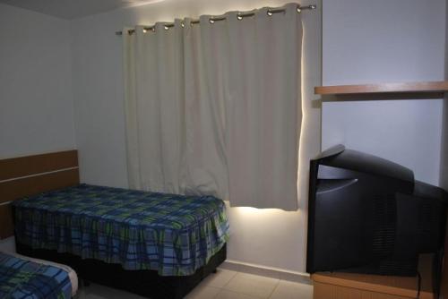 1 dormitorio con 1 cama y TV en Prive das Thermas II - Achei Ferias, en Caldas Novas