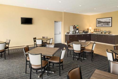 a dining room with tables and chairs and a kitchen at Travelodge by Wyndham Sydney in Sydney