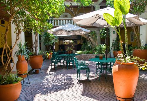 a patio with tables and chairs and potted plants at Parador del Dominico in Oaxaca City