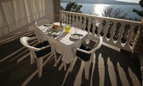 a white table and chairs on a balcony at Villa Marijana-Direktno na moru in Seline