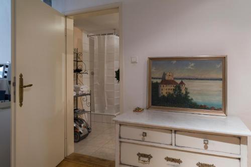 a painting of a house on a dresser in a bathroom at Haus zum Einhörnle in Konstanz