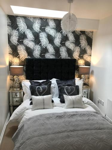 a bedroom with a large bed with a black and white wall at Luxury 2 bed Apartment in Witney