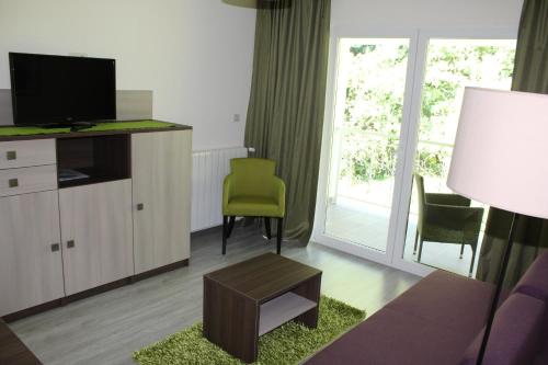a living room with a couch and a tv at Hotel Stanger in Lovran