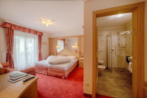 a hotel room with a bed and a bathroom at Hotel Mair in Campo Tures