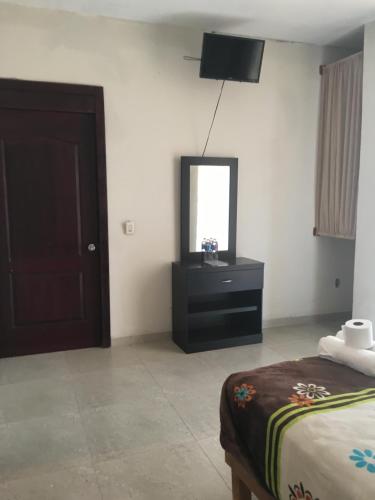 a bedroom with a bed and a dresser and a mirror at Hotel Coatlicue in San Juan Teotihuacán