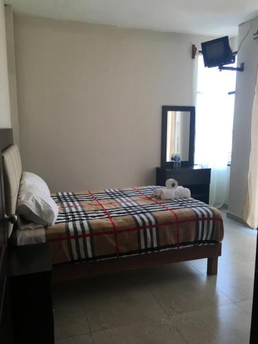 a bedroom with a bed with a teddy bear on it at Hotel Coatlicue in San Juan Teotihuacán