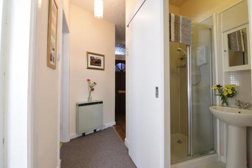 a bathroom with a sink and a shower and a toilet at Mansfield Apartment in Hawick