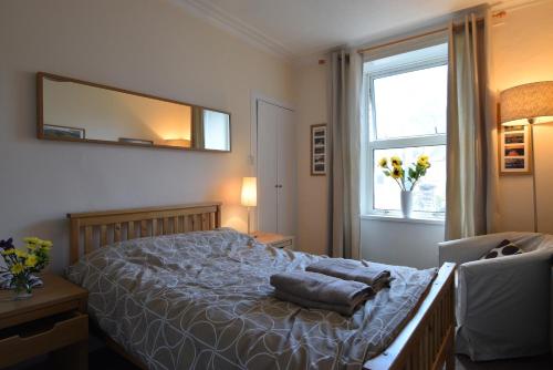 a bedroom with a bed and a mirror on the wall at Mansfield Apartment in Hawick