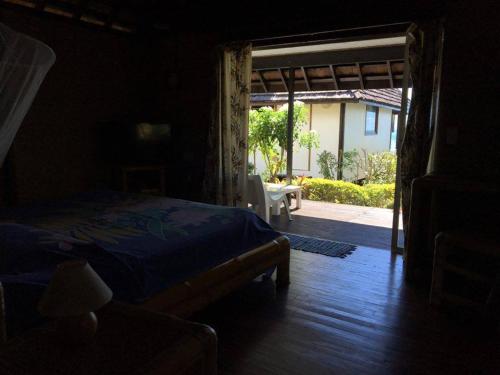 a bedroom with a bed and an open door to a patio at Pension Motu Iti in Pihaena