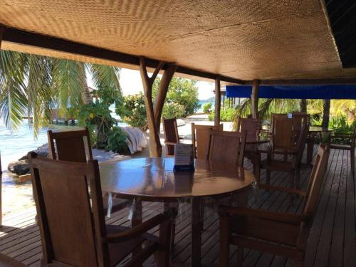 a wooden table and chairs on a deck with a table and chairs at Pension Motu Iti in Pihaena