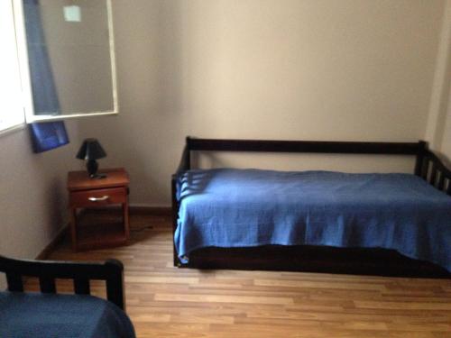 1 dormitorio con cama azul y mesita de noche en Apartamento en el centro de mercedes URUGUAY, en Mercedes
