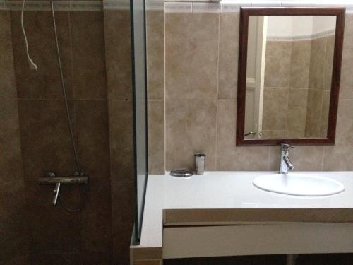 a bathroom with a sink and a shower with a mirror at Apartamento en el centro de mercedes URUGUAY in Mercedes