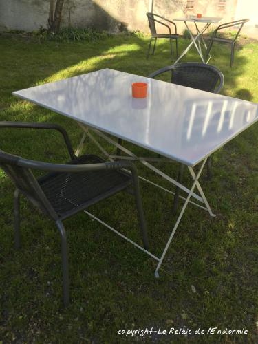 a table and chairs with a cup on top of it at Le Relais de l'endormie in Nogent-sur-Seine