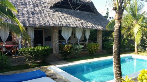 a resort with a swimming pool in front of a building at Villa Isla del Amore in Watamu