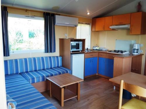 un salon avec un canapé et une cuisine dans l'établissement La Canardiere, à Casta