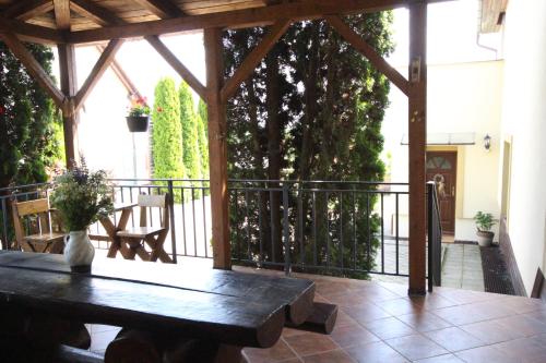 a wooden pergola with a wooden table on a patio at Penzion Živá Pálava in Klentnice