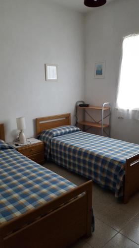 a bedroom with two beds and a table and a window at Casa Tina in Pomonte