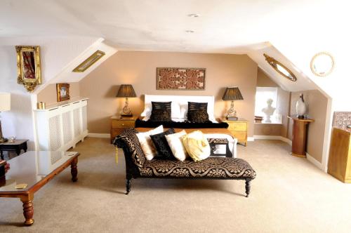 1 dormitorio grande con 1 cama y 1 sofá en The Globe Inn en Chagford